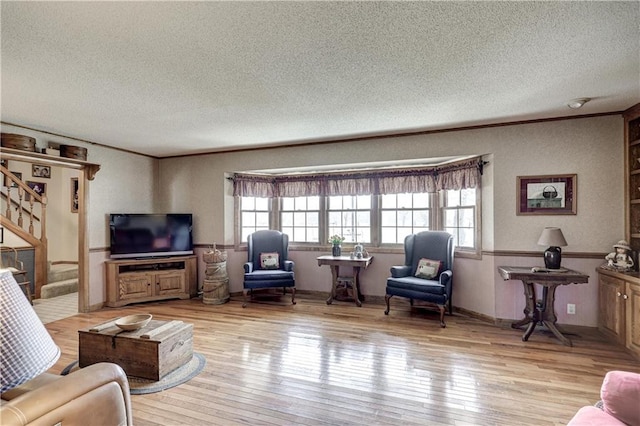 living room with a healthy amount of sunlight, crown molding, and hardwood / wood-style flooring