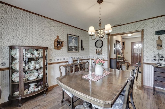 dining room featuring wallpapered walls and a wainscoted wall