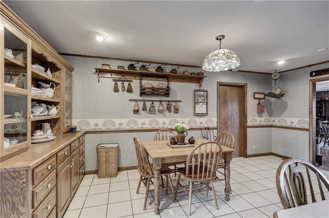 dining area with ornamental molding, light tile patterned floors, and a textured ceiling