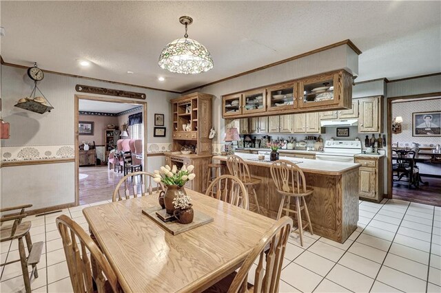 dining area with light tile patterned floors, a textured ceiling, and ornamental molding