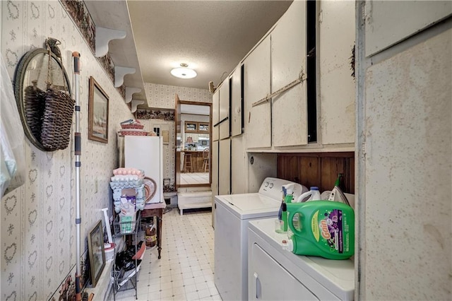 washroom featuring light floors, wallpapered walls, cabinet space, a textured ceiling, and washing machine and dryer