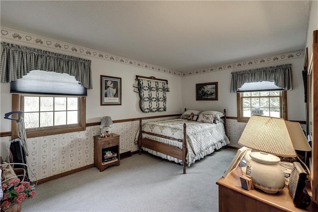 carpeted bedroom with multiple windows, wallpapered walls, and baseboards