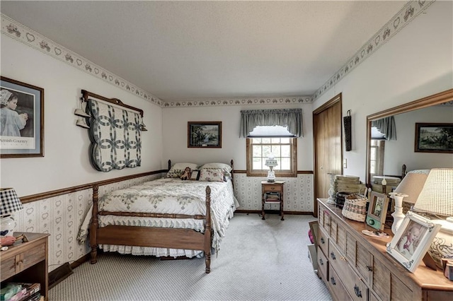 bedroom with light carpet, wallpapered walls, and baseboards