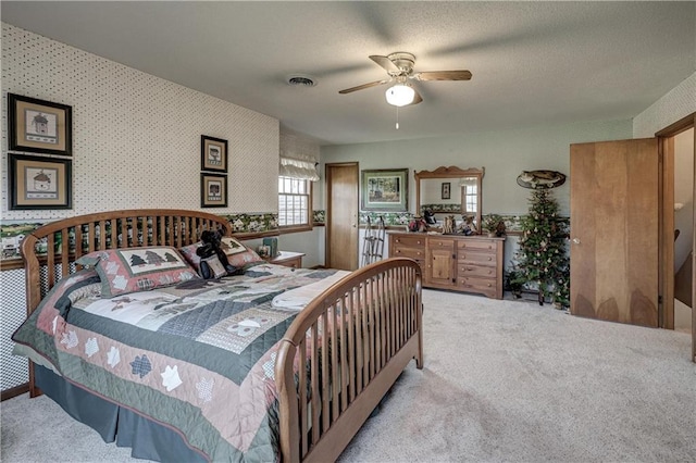 bedroom featuring visible vents, a textured ceiling, carpet flooring, and wallpapered walls