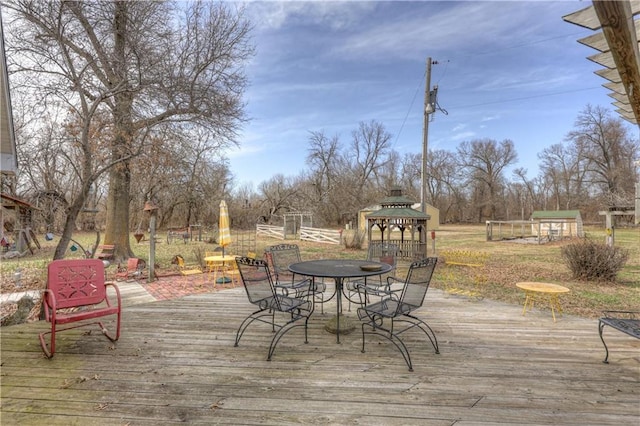 wooden deck featuring a gazebo and outdoor dining area