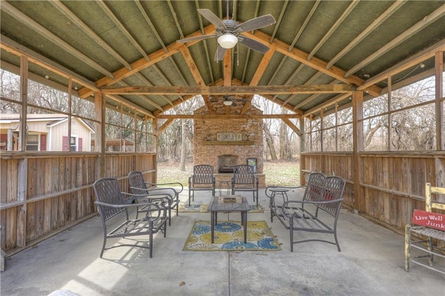 view of patio with an outdoor living space with a fireplace and a ceiling fan