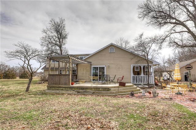 rear view of property with a wooden deck, a pergola, and a yard