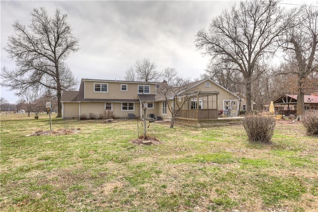 back of property with a wooden deck and a yard