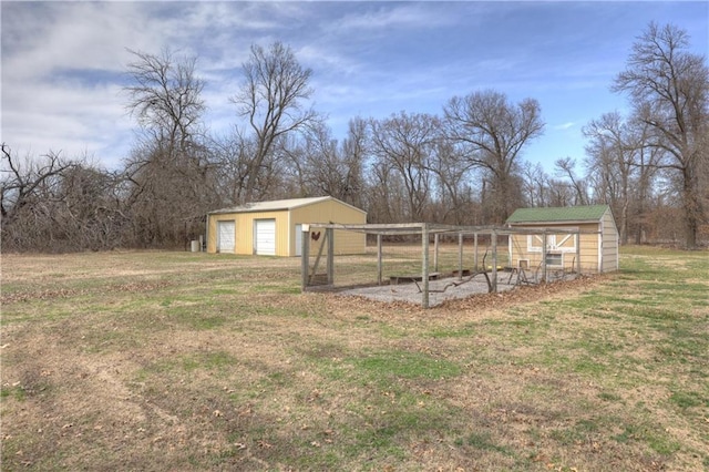 view of yard featuring a garage, an outbuilding, and exterior structure