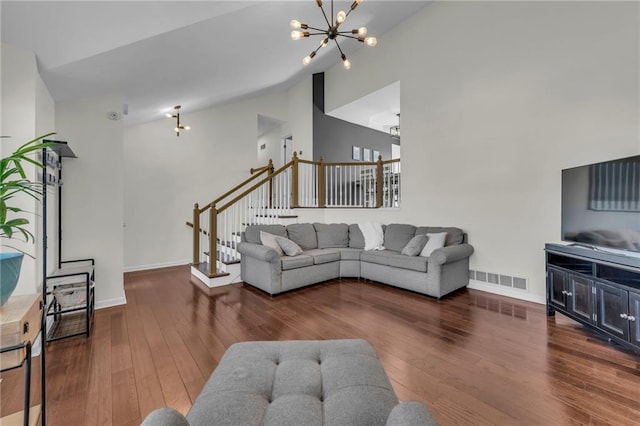 living area featuring a notable chandelier, stairway, and wood finished floors