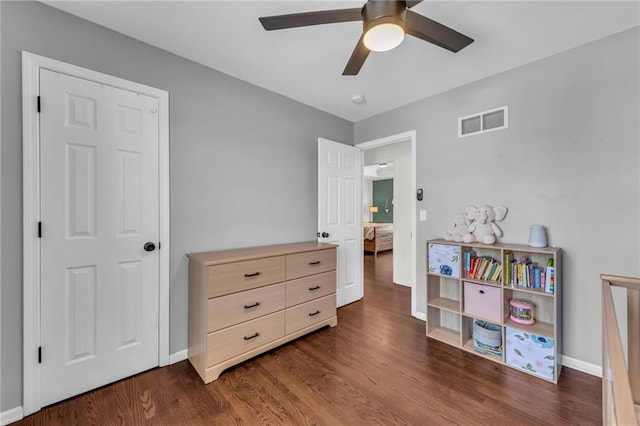 bedroom featuring visible vents, baseboards, dark wood-type flooring, and a ceiling fan