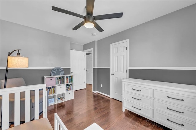 bedroom featuring baseboards, dark wood finished floors, and a ceiling fan