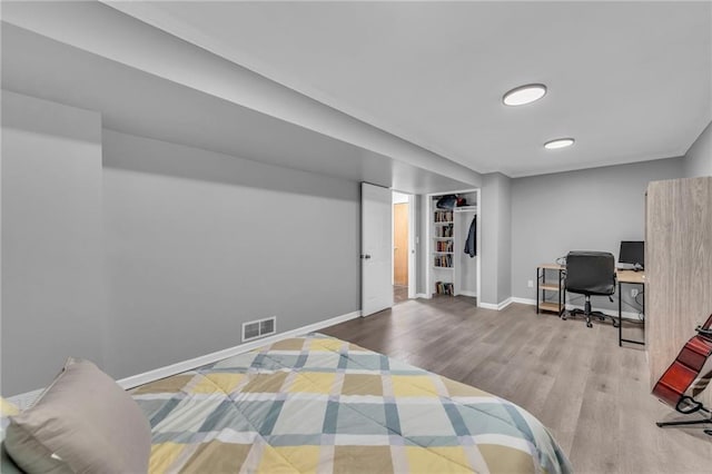 bedroom featuring visible vents, baseboards, and wood finished floors