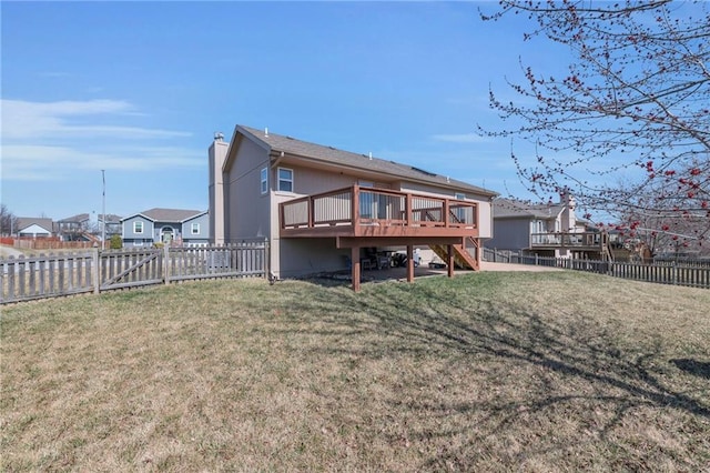 rear view of house featuring a wooden deck, a lawn, a fenced backyard, and stairs