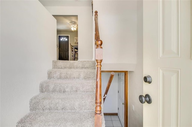 stairs featuring tile patterned floors and ceiling fan