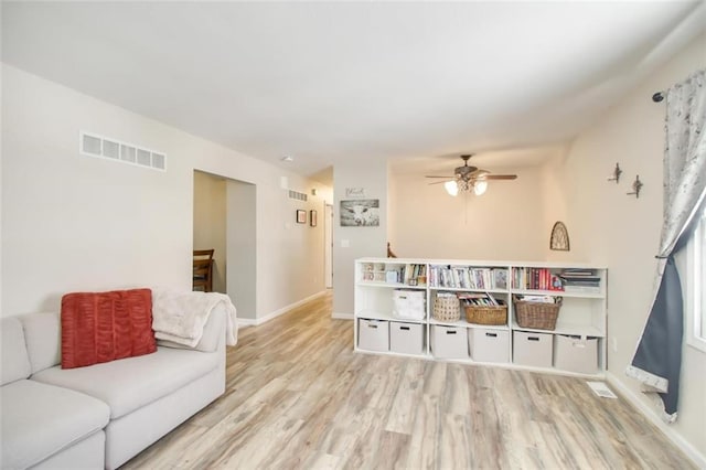 living room with visible vents, baseboards, ceiling fan, and wood finished floors