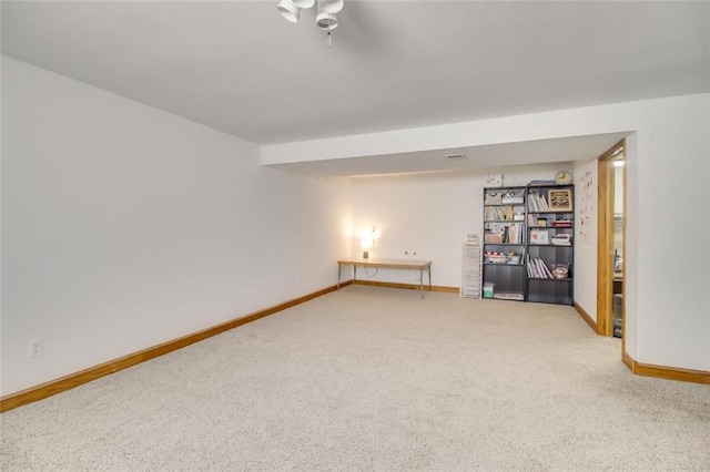 empty room with a ceiling fan, baseboards, and carpet floors