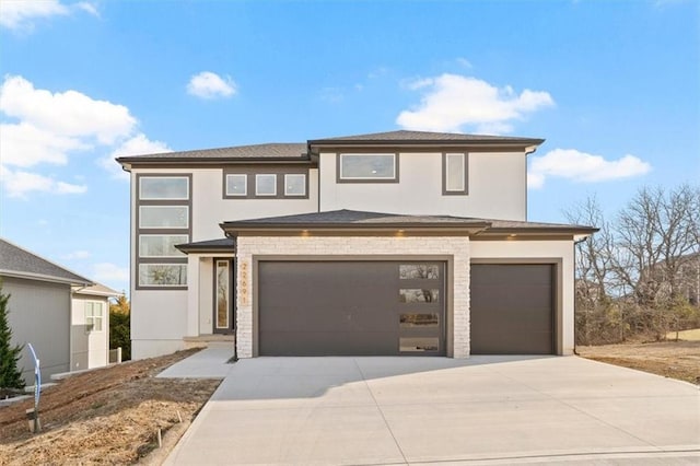 prairie-style house featuring stucco siding, concrete driveway, and a garage