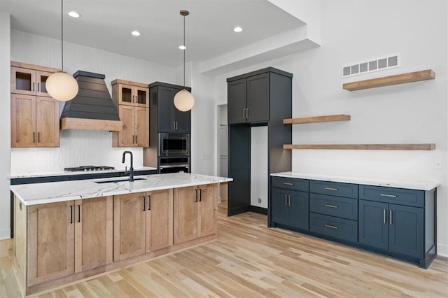 kitchen featuring visible vents, open shelves, custom range hood, appliances with stainless steel finishes, and a sink