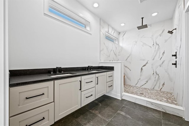 bathroom featuring recessed lighting, a marble finish shower, and a sink