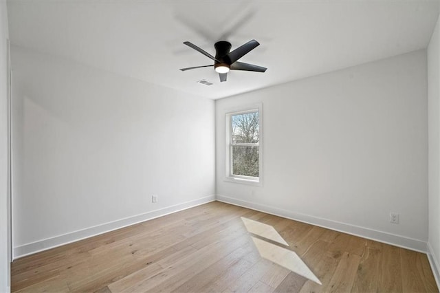 unfurnished room featuring a ceiling fan, wood finished floors, visible vents, and baseboards