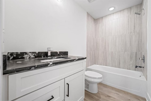 full bathroom with toilet, wood finished floors, recessed lighting, tub / shower combination, and vanity