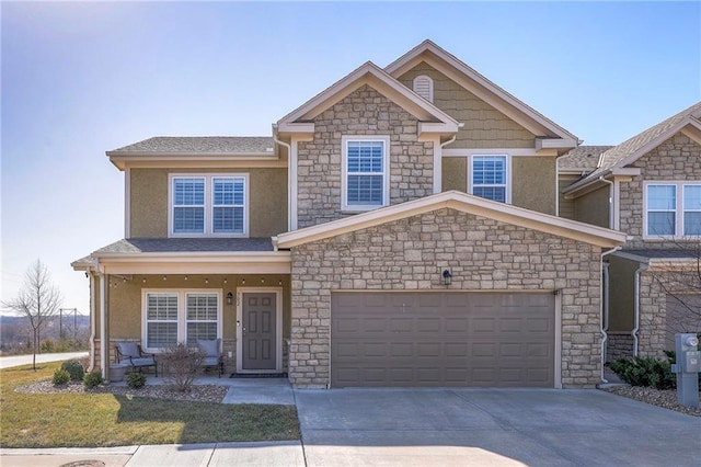 craftsman house featuring stone siding, driveway, and an attached garage