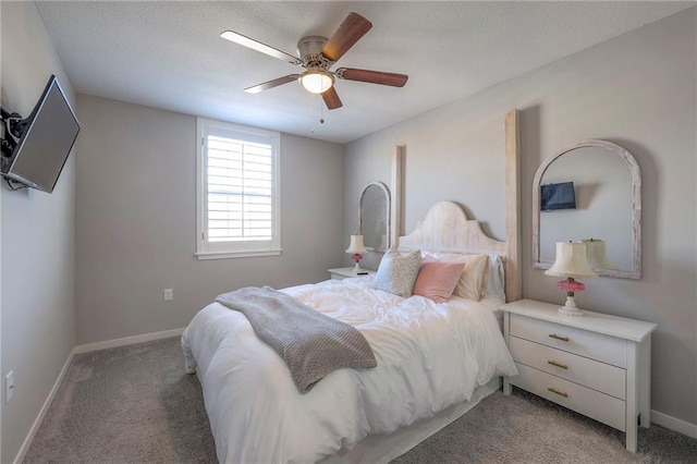 bedroom featuring light colored carpet, a textured ceiling, baseboards, and a ceiling fan