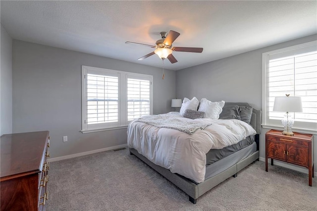 carpeted bedroom with visible vents, ceiling fan, and baseboards