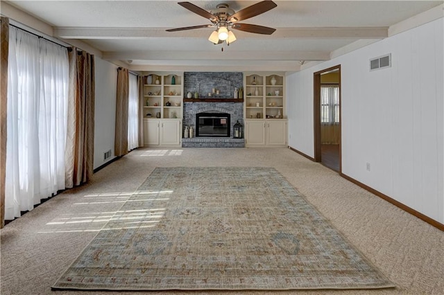 unfurnished living room featuring baseboards, visible vents, beam ceiling, ceiling fan, and light colored carpet