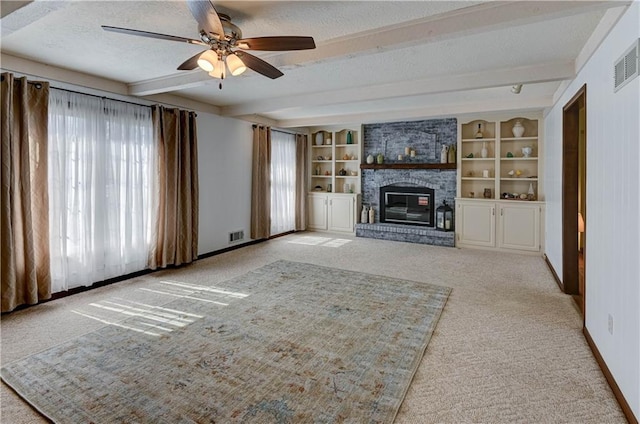 unfurnished living room featuring beam ceiling, a ceiling fan, a textured ceiling, baseboards, and light colored carpet