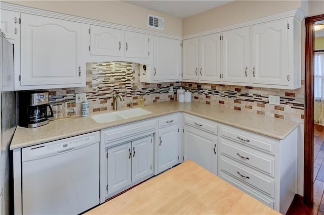 kitchen featuring a sink, visible vents, white cabinets, and white dishwasher