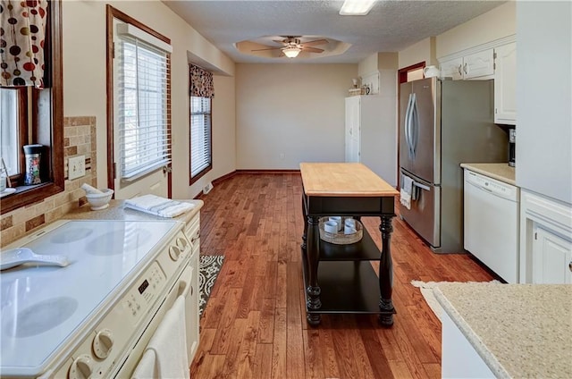 kitchen with a textured ceiling, white cabinetry, white appliances, light wood-style floors, and ceiling fan