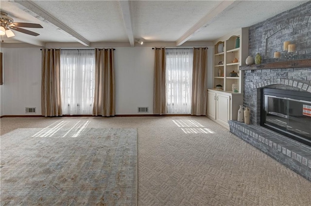 unfurnished living room with beamed ceiling, a ceiling fan, visible vents, and a textured ceiling