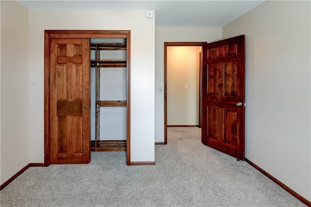 unfurnished bedroom featuring a closet, baseboards, and carpet flooring