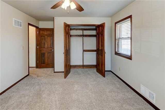 unfurnished bedroom featuring light colored carpet, visible vents, a closet, and baseboards