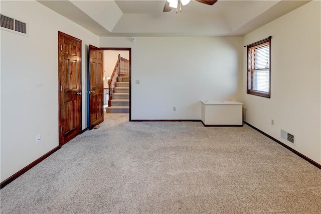 spare room with visible vents, baseboards, a raised ceiling, and a ceiling fan