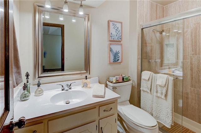 full bathroom with toilet, a stall shower, and vanity