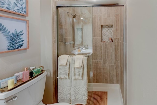 bathroom with toilet and a shower stall