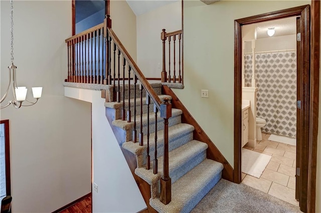 stairway with a notable chandelier