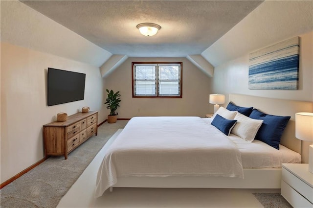 bedroom with light colored carpet, a textured ceiling, baseboards, and vaulted ceiling