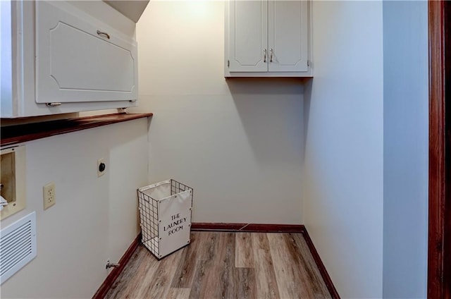 washroom featuring wood finished floors, baseboards, hookup for an electric dryer, visible vents, and cabinet space