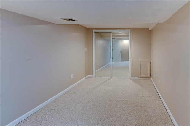 unfurnished room featuring light carpet, visible vents, and baseboards