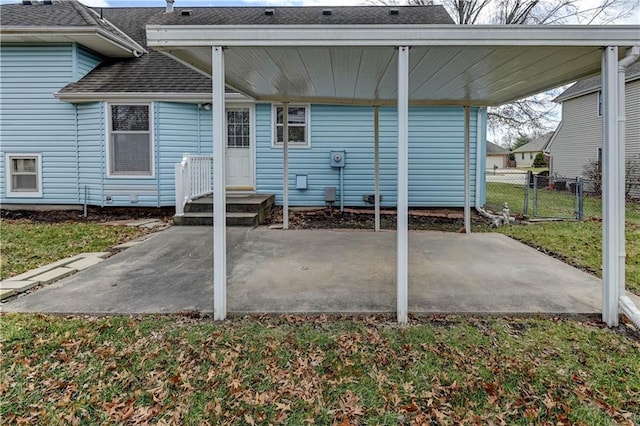 rear view of house featuring fence, roof with shingles, a lawn, a patio, and a gate