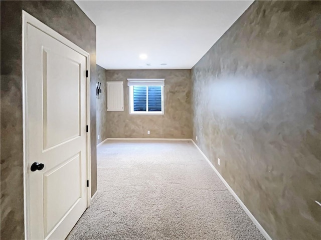 carpeted spare room featuring baseboards