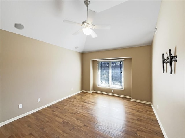 unfurnished room with wood finished floors, a ceiling fan, baseboards, and lofted ceiling