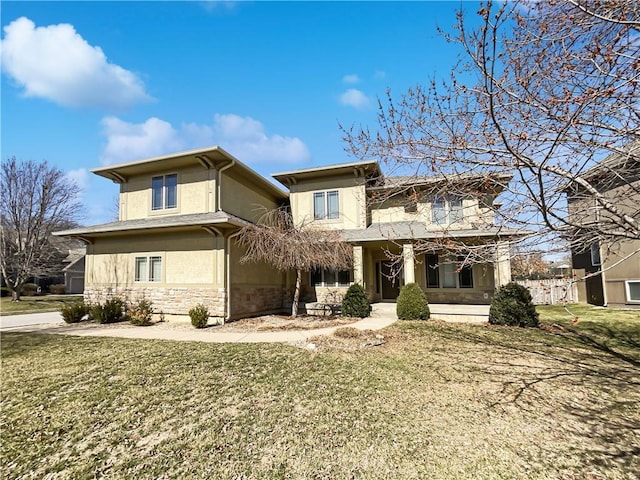 view of front of house featuring stucco siding, stone siding, and a front lawn