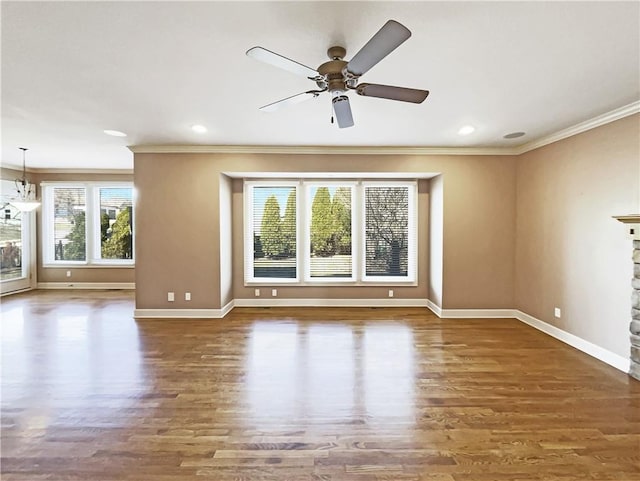 unfurnished living room featuring ceiling fan, baseboards, wood finished floors, and crown molding