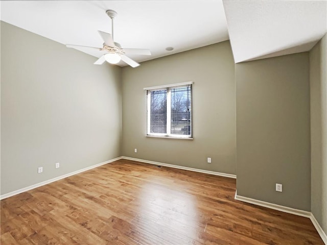 unfurnished room featuring a ceiling fan, wood finished floors, and baseboards