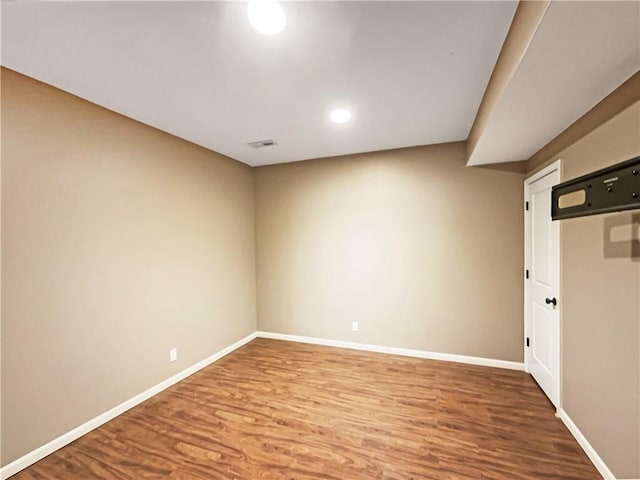 empty room featuring visible vents, baseboards, and wood finished floors